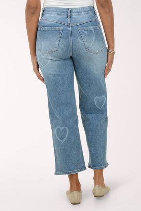 Woman wearing a white lace top and blue jeans on a white background