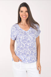 Woman wearing a blue floral patterned shirt on a white background