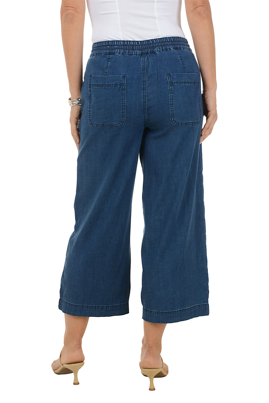 Blue denim pants worn by a person on a white background