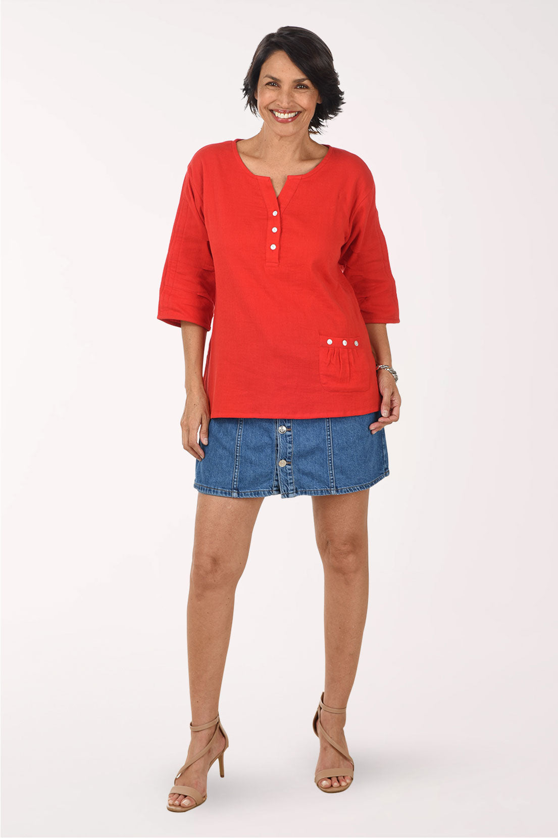 Woman wearing a red top and blue skirt on a white background