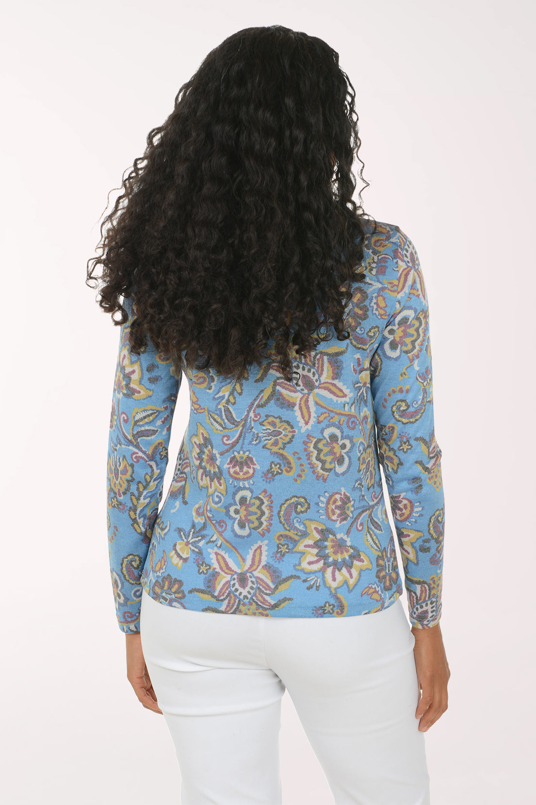Woman wearing a blue long sleeve top with a funnel neckline and a floral pattern