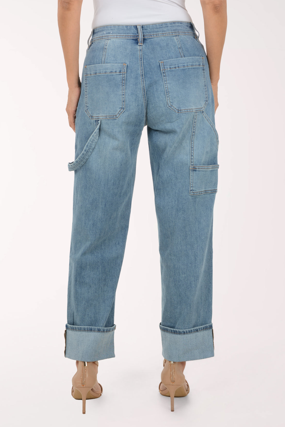A model wearing light-wash blue denim jeans with a rolled cuff, side cargo pockets, and a striped fabric tie belt, paired with beige high-heeled sandals against a plain white background.