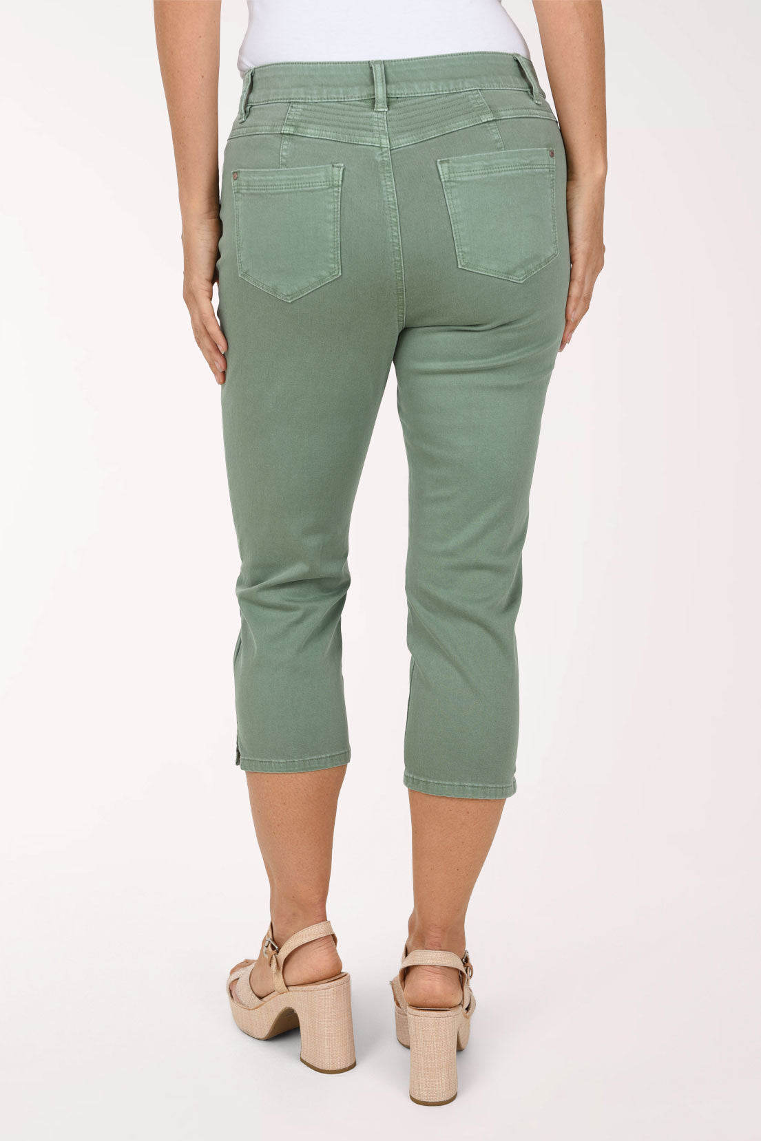 Back view of sage green Moss stretch denim capri pants showing topstitched back patch pockets and the stitched back waistband.