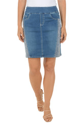 Blue denim skirt with contoured side panels bejeweled with glittery rhinestones worn by a person on a white background.