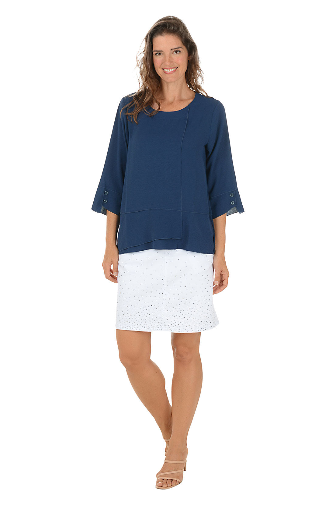 Woman wearing a navy blue top and white skirt on a white background