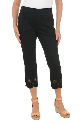 Black pants with floral embroidery at the bottom worn by a person on a white background.
