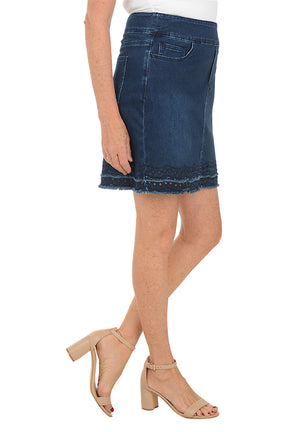 Person wearing a blue denim skirt on a white background. Side shot.