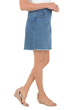Denim skirt worn by a person on a white background. Side shot.