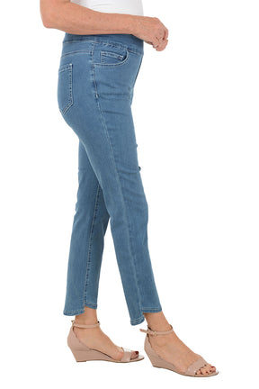 Blue jeans worn by a person on a white background. Side shot.