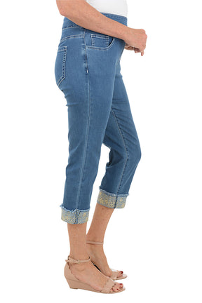 Blue jeans worn by a person on a white background. Side shot.