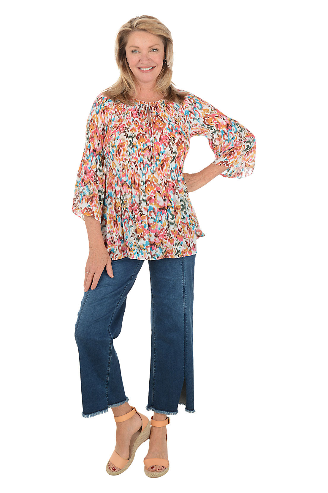 Woman wearing a floral blouse and blue jeans on a white background
