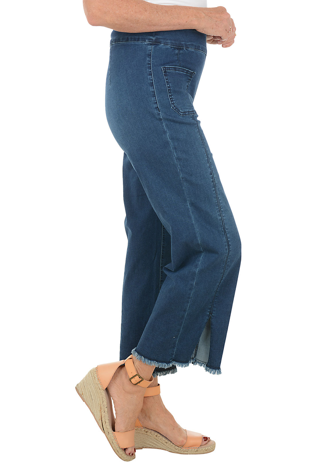 Blue jeans with a slit on a white background. Side shot.