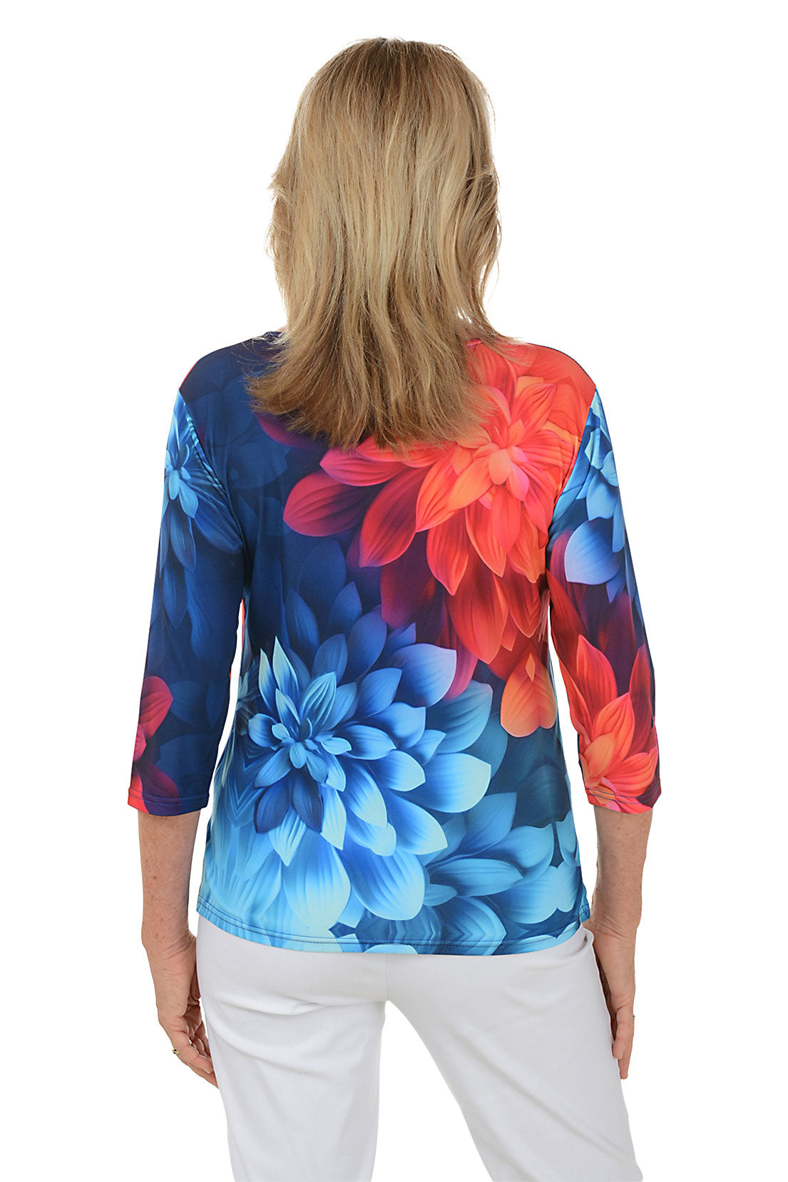 Woman wearing a colorful floral top with a white background. Back shot.