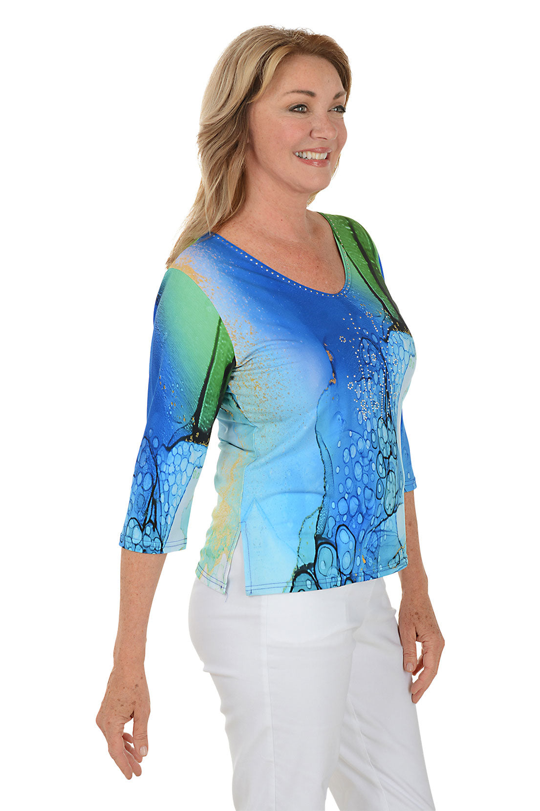 Woman wearing a colorful abstract patterned top on a white background. Side shot.