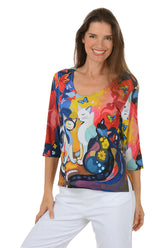 Woman wearing a colorful blouse with cat design on a white background.