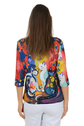 Woman wearing a colorful blouse with cat design on a white background. Back shot.