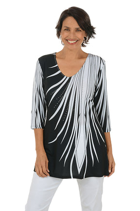 Woman wearing a black and white patterned top on a white background.