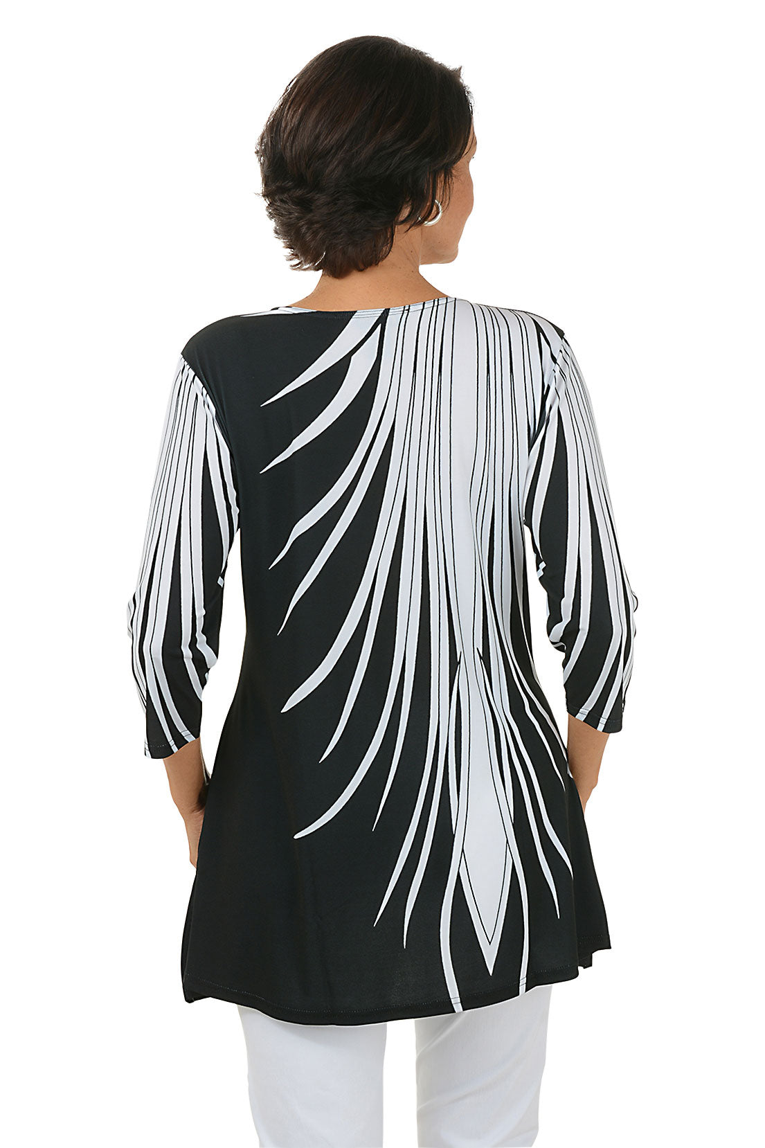 Woman wearing a black and white patterned top on a white background. Back shot.