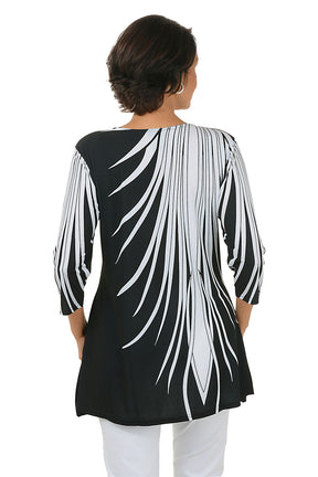 Woman wearing a black and white patterned top on a white background. Back shot.