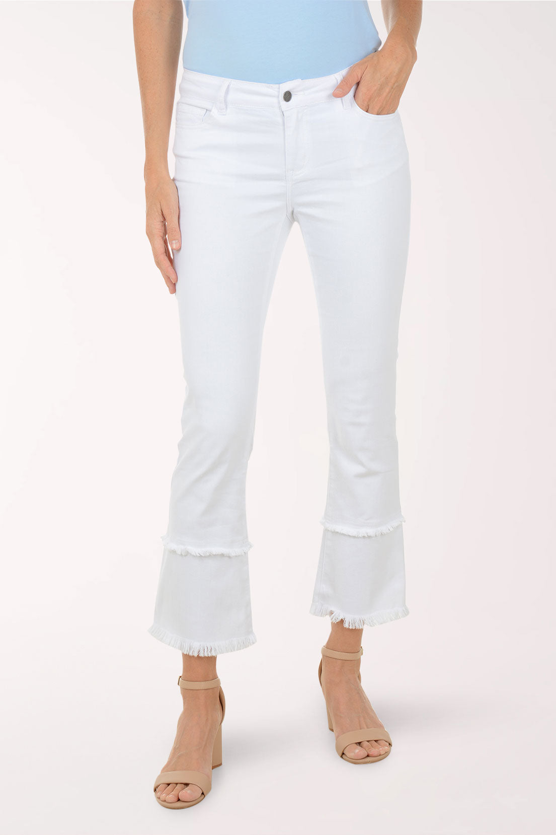 Person wearing white cropped jeans on a plain background