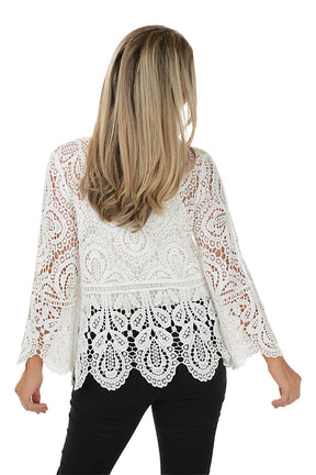 Woman wearing a white lace top on a white background. Back shot.