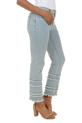 Light blue jeans with frayed hem worn by a person on a white background. Side shot.