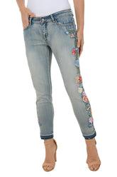 Light blue jeans with floral embroidery on a white background.