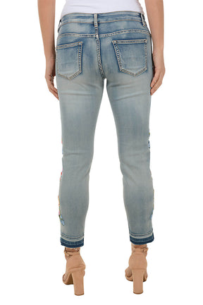 Light blue jeans with floral embroidery on a white background. Back shot.