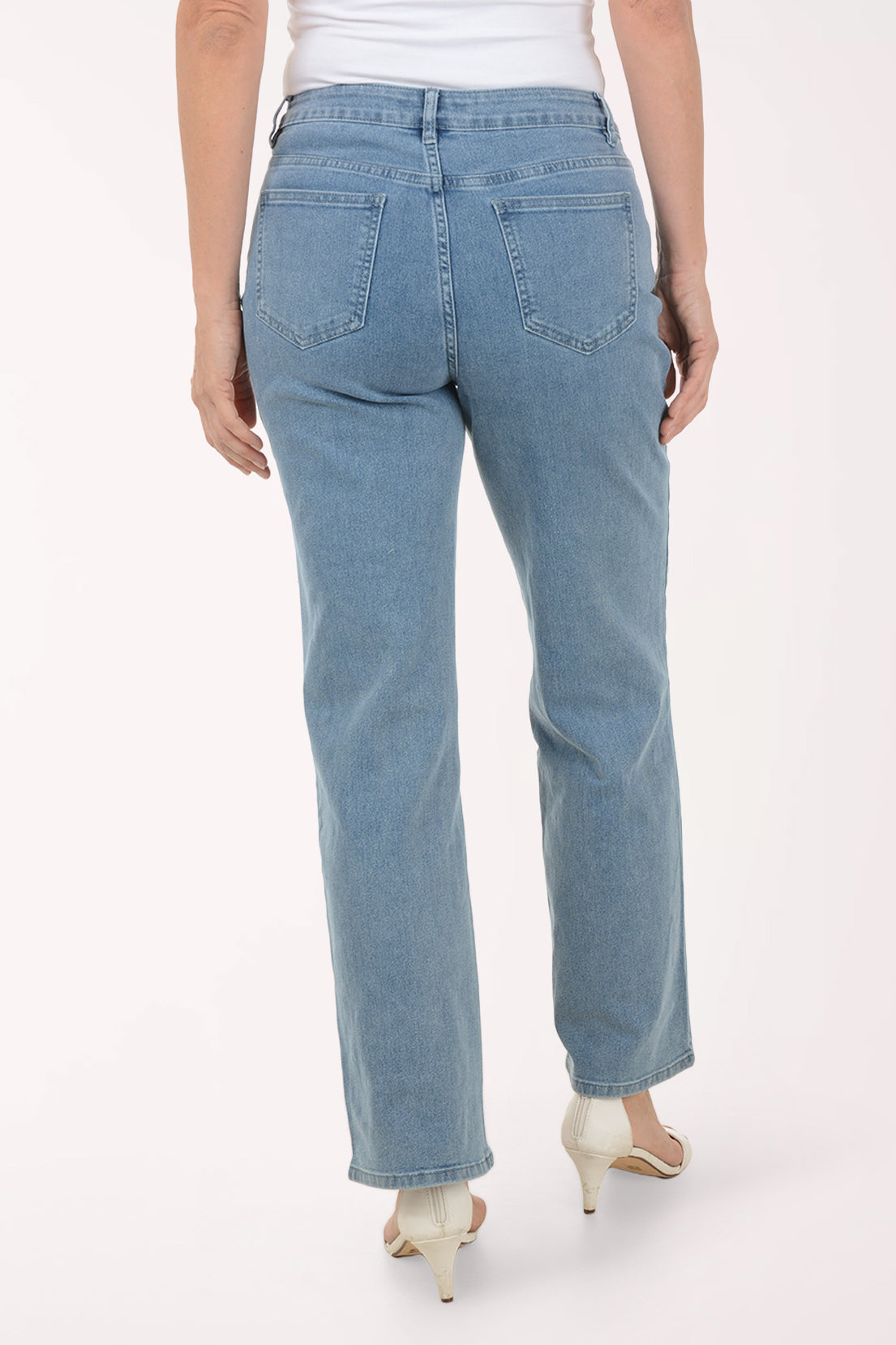 Person wearing blue jeans with white speckles on a white background