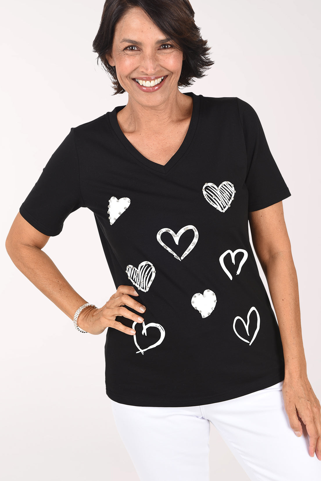Front close-up of the black V-neck tee showing the screenprinted white and silver hearts with rhinestone sparkle and the short sleeves.