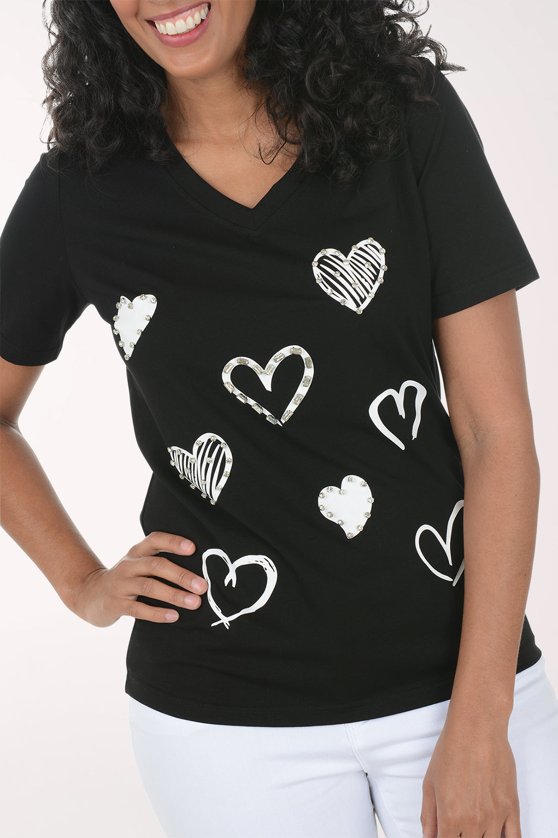 Person wearing a black t-shirt with white heart patterns on a white background