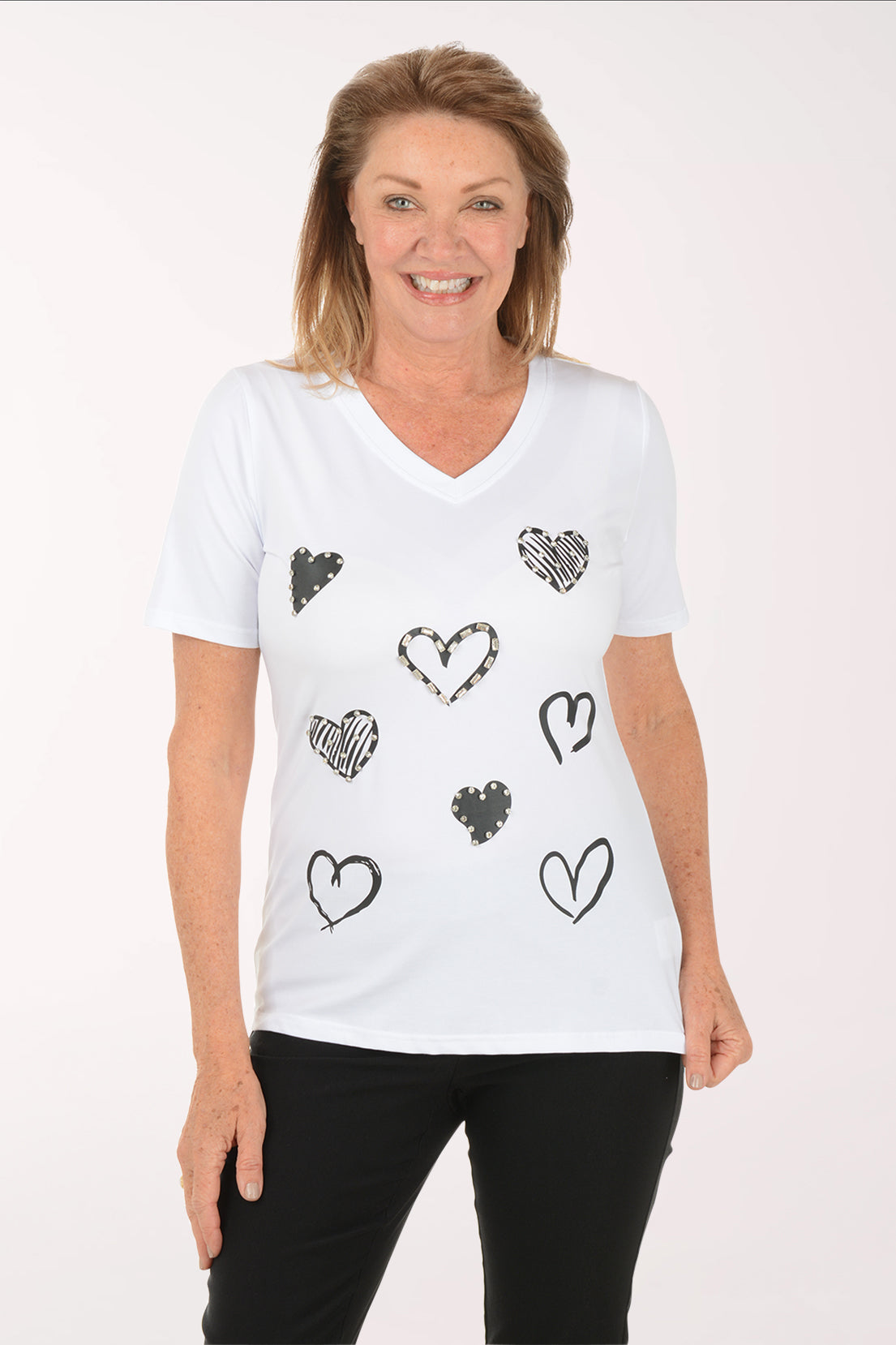 Woman wearing a white t-shirt with black heart designs on a white background