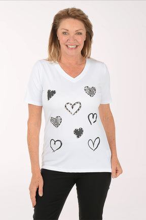 Woman wearing a white t-shirt with black heart designs on a white background