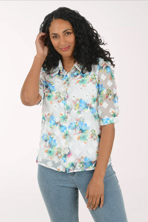 Woman wearing a floral shirt and jeans on a white background