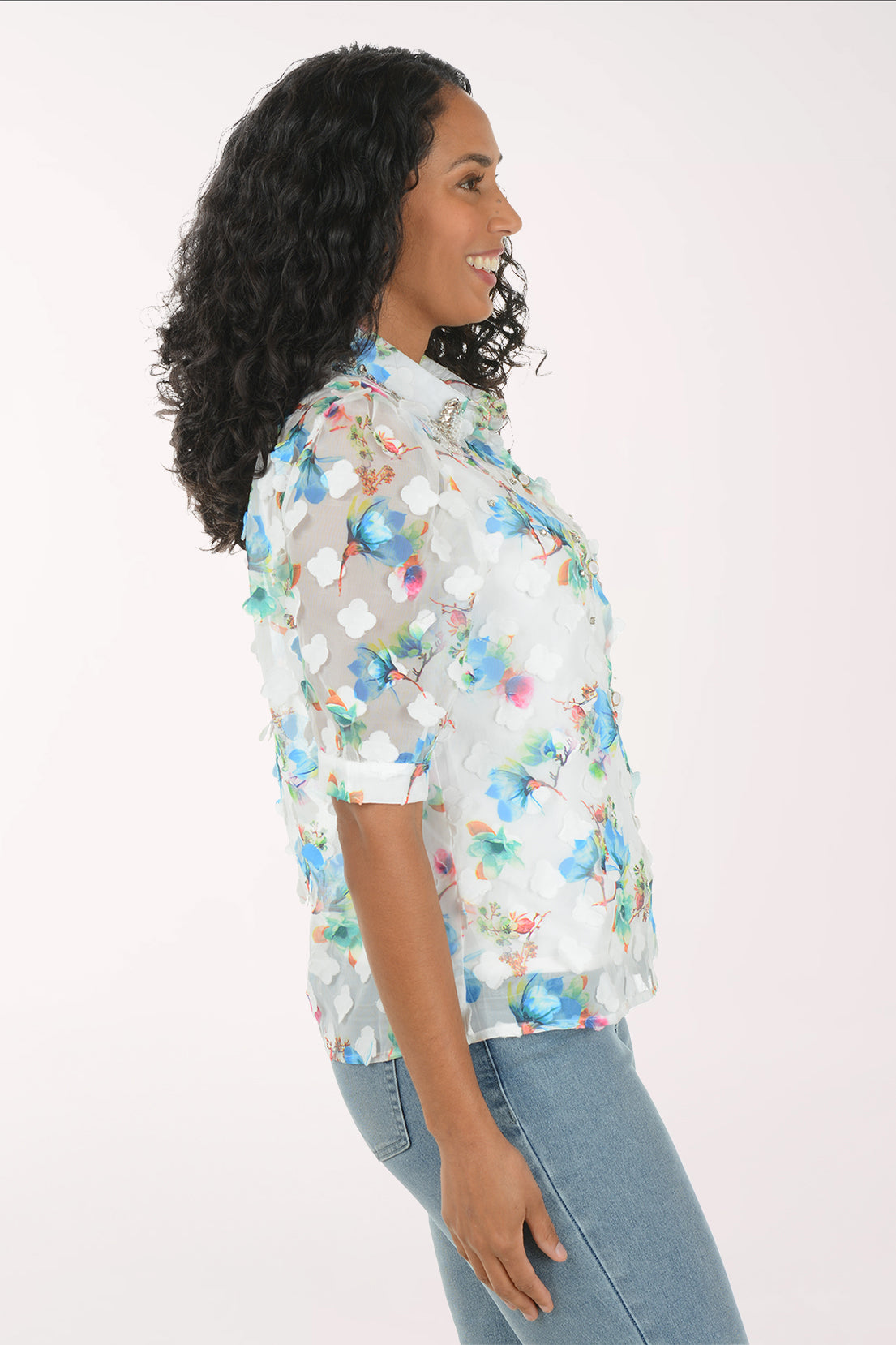 Woman wearing a floral shirt and jeans on a white background