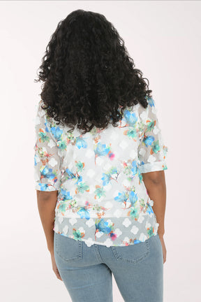 Woman wearing a floral shirt and jeans on a white background