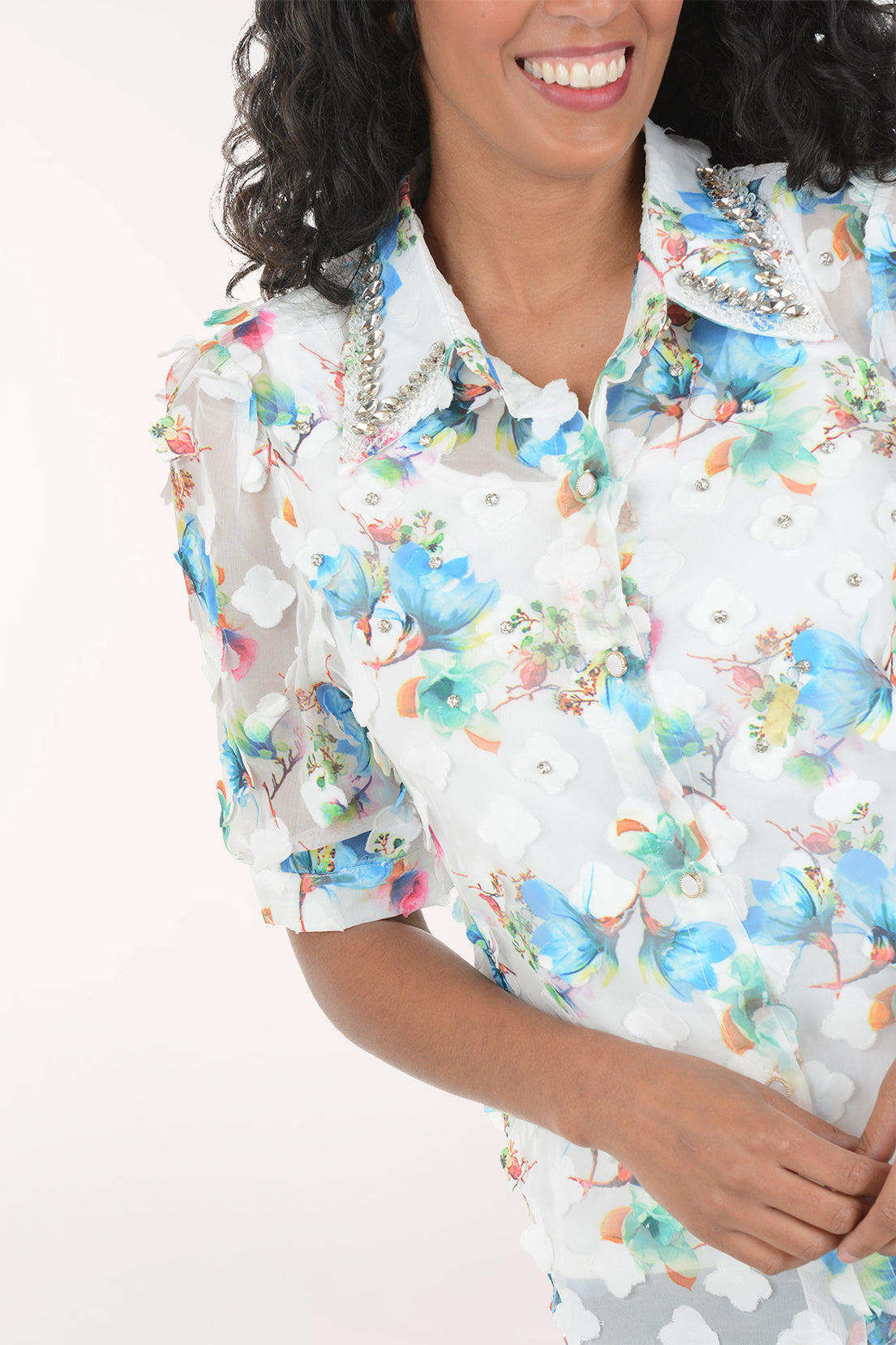 Woman wearing a floral shirt and jeans on a white background
