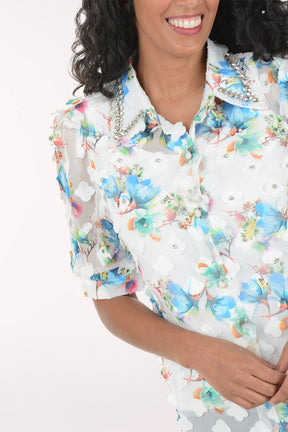 Woman wearing a floral shirt and jeans on a white background