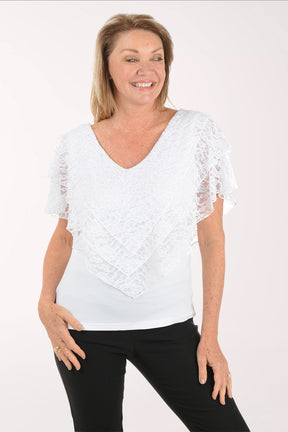 Woman wearing a white lace top and black pants on a white background