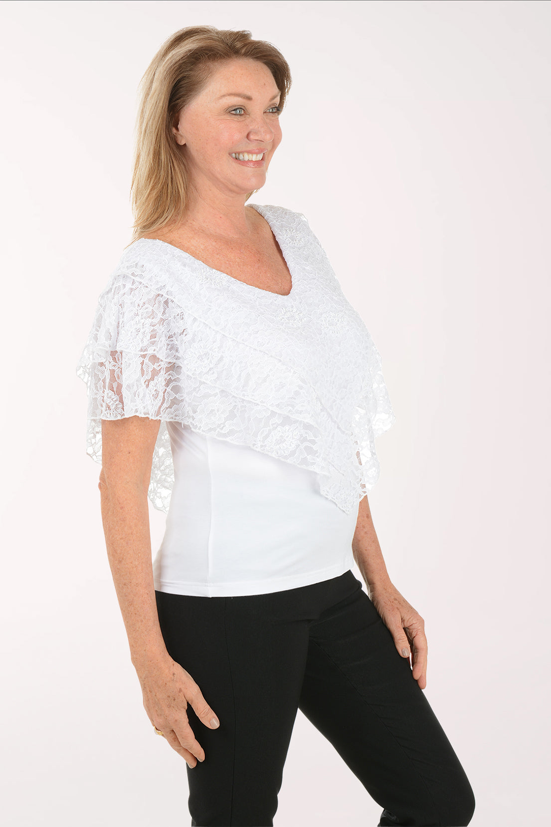Woman wearing a white lace top and black pants on a white background