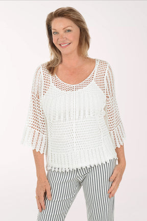 Woman wearing a white crochet top and striped pants on a white background