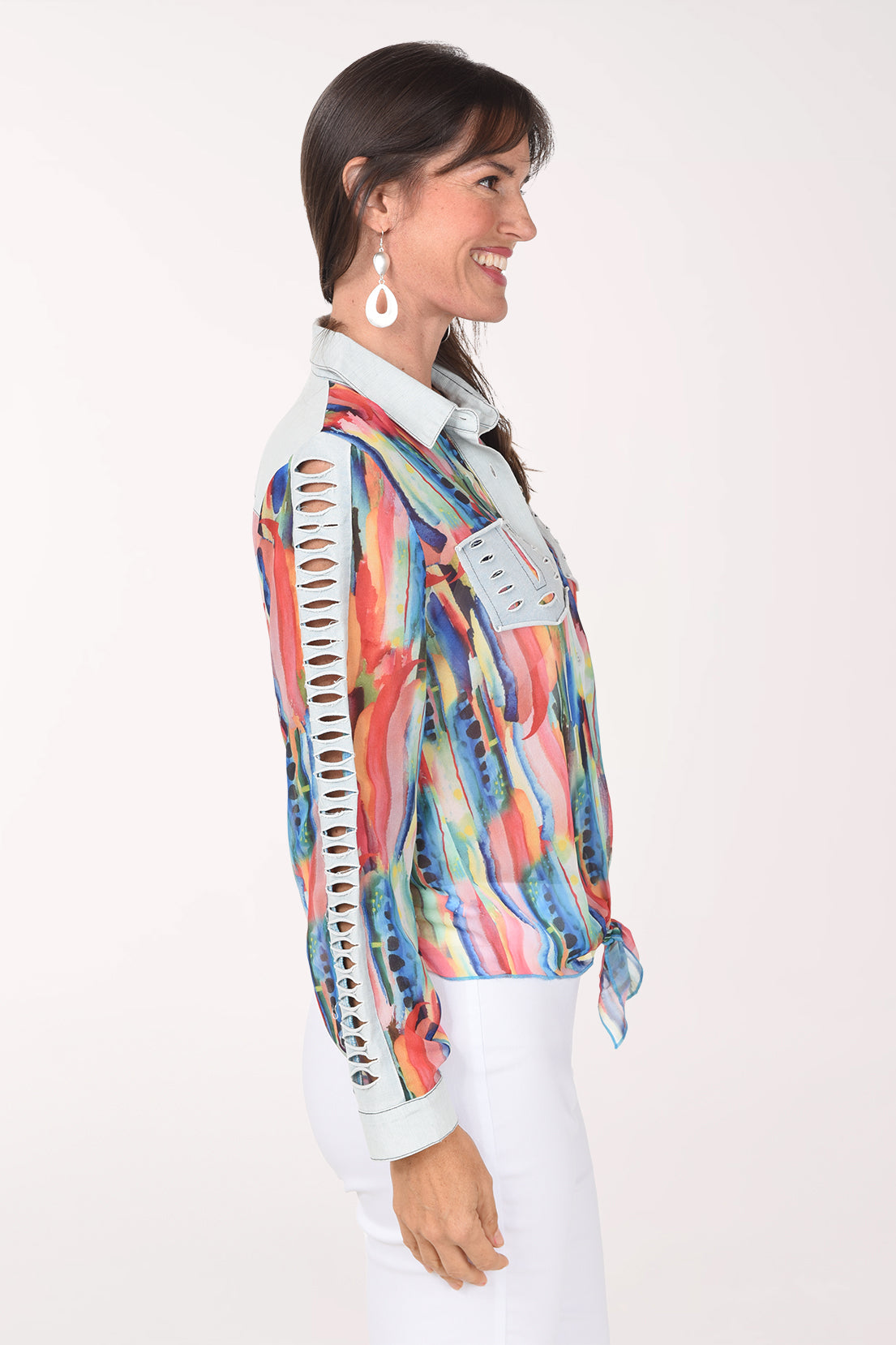 Side view of the orange watercolor shirt showing the ladder of distressed denim cutouts down the sleeve and the tied hem.