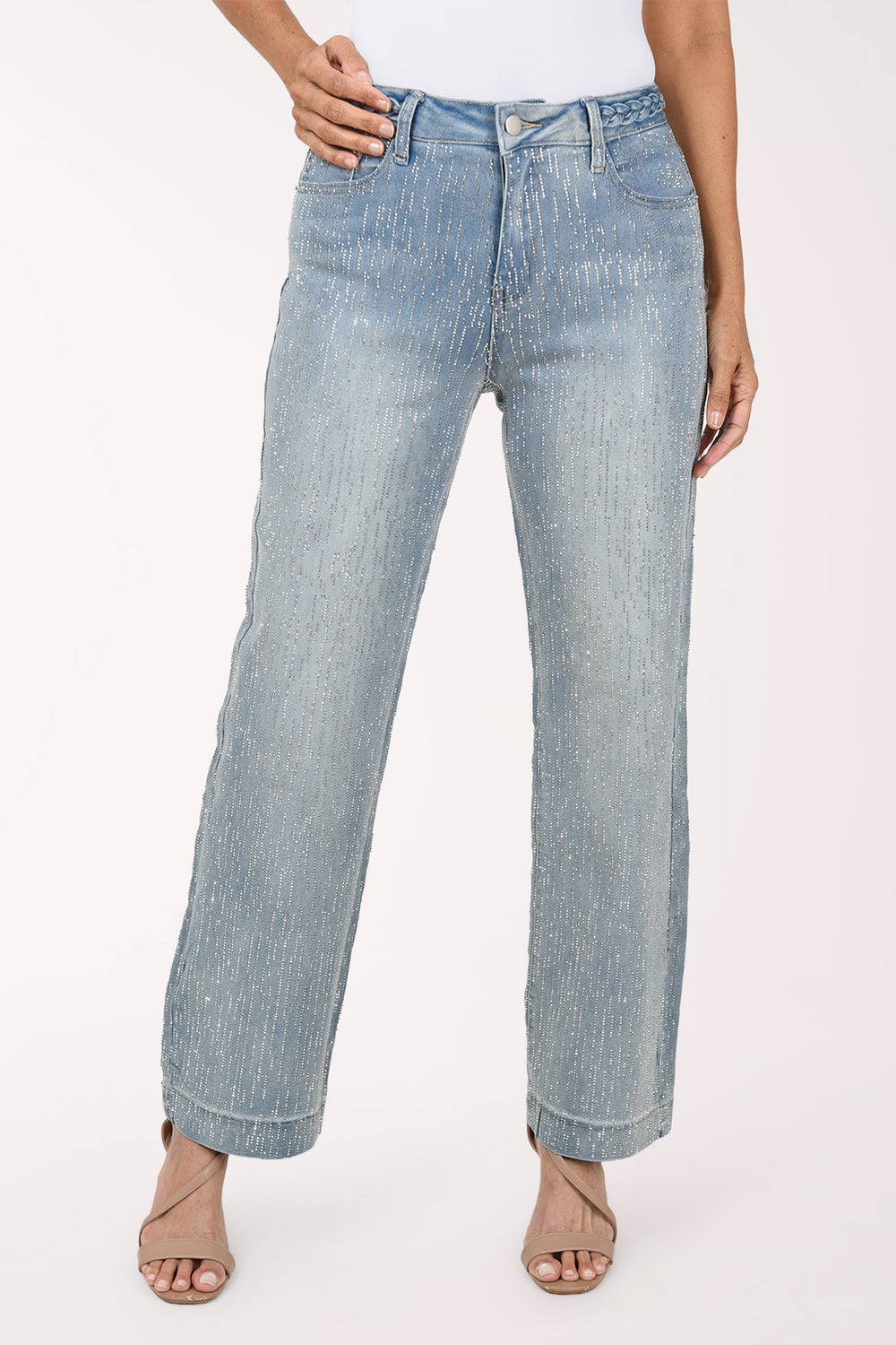 Front view of light-wash stretch denim wide leg pants covered in fine vertical rows of rhinestones, with five-pocket styling, worn with a white top and nude heeled sandals.