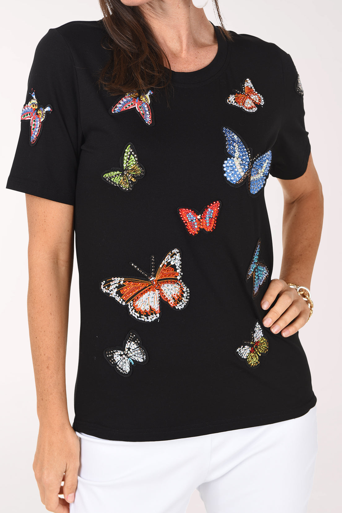 Front close-up of the black butterfly tee showing the jeweled butterfly appliques and short sleeves.