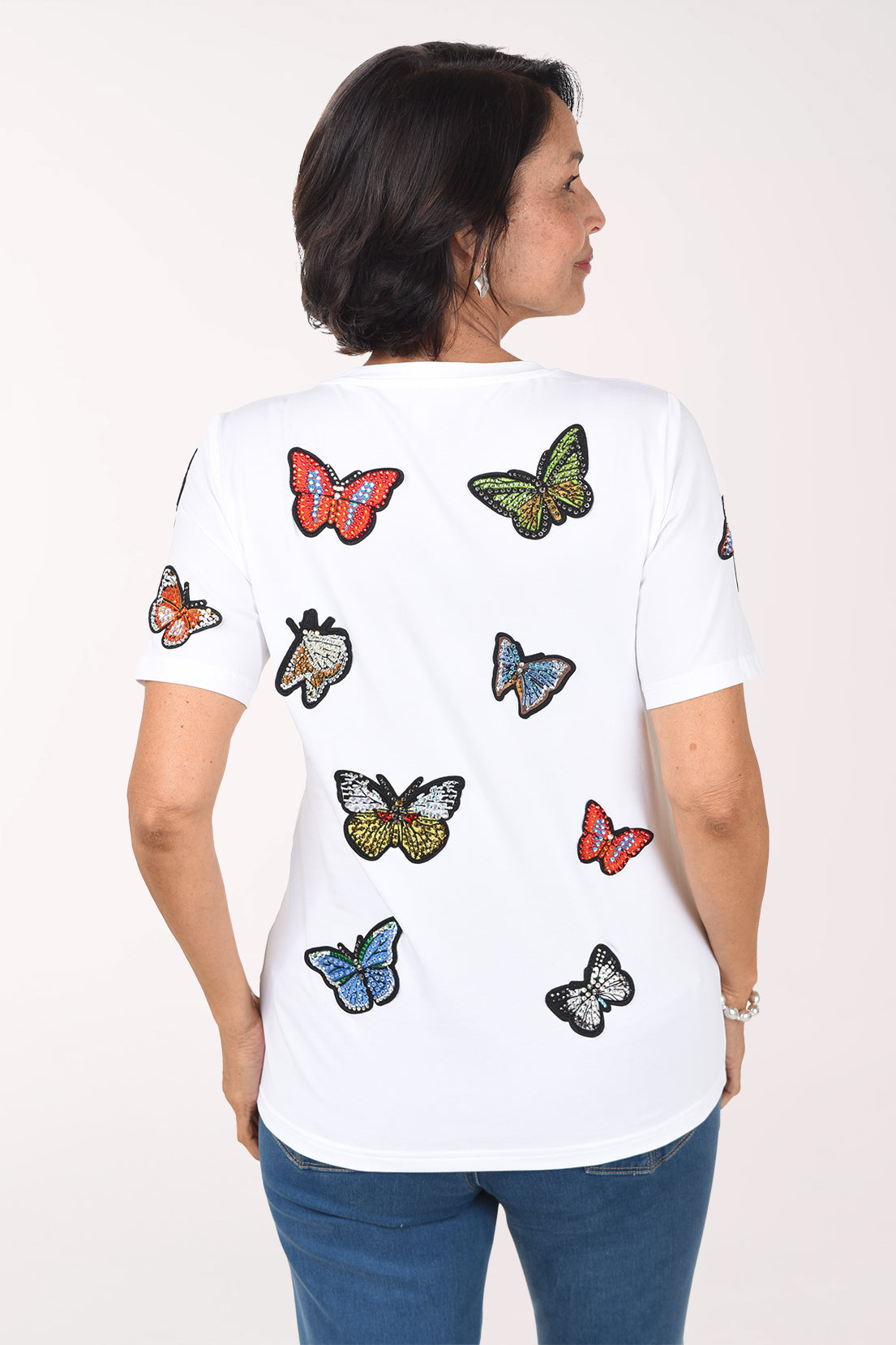 Back view of the white butterfly tee showing jeweled butterfly appliques across the back.
