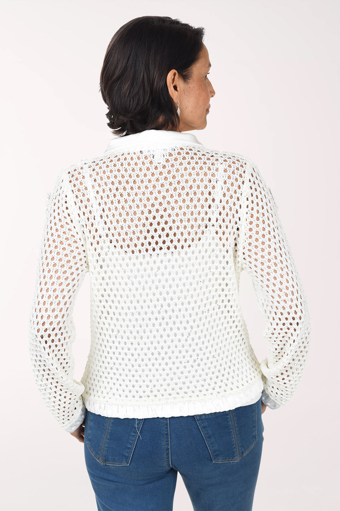 Back view of the ivory crochet sweater jacket showing the open crochet back, satin collar and satin hem.