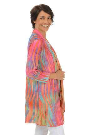 Woman wearing a colorful cardigan on a white background. Side shot.
