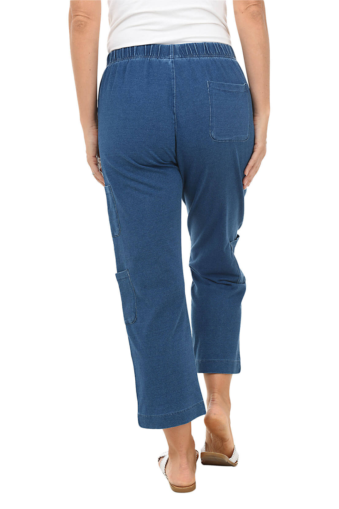 Woman wearing blue pants on a white background. Back shot.