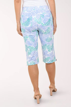 Person wearing light blue capri pants with a leaf pattern on a white background