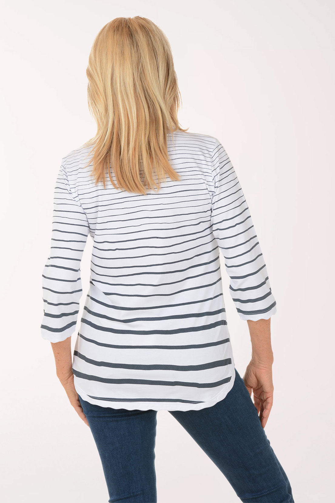 Woman wearing a striped shirt and jeans on a white background